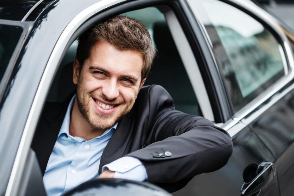 Satisfied driver smiling out car window